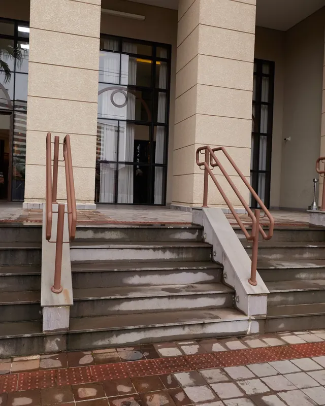 Escadaria de entrada do prédio, com corrimão